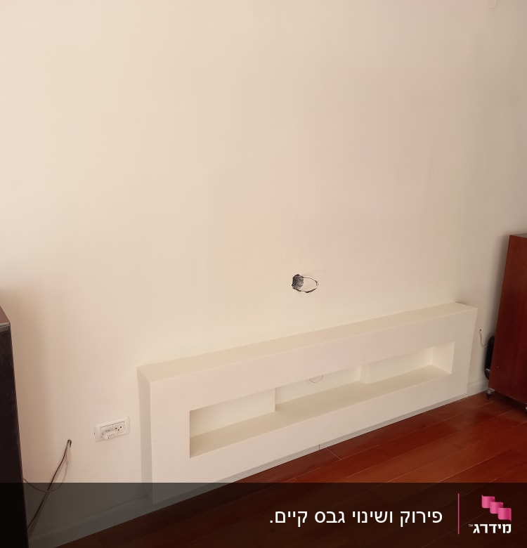 קיר גבס עם חור וחוטים חשמליים חשופים